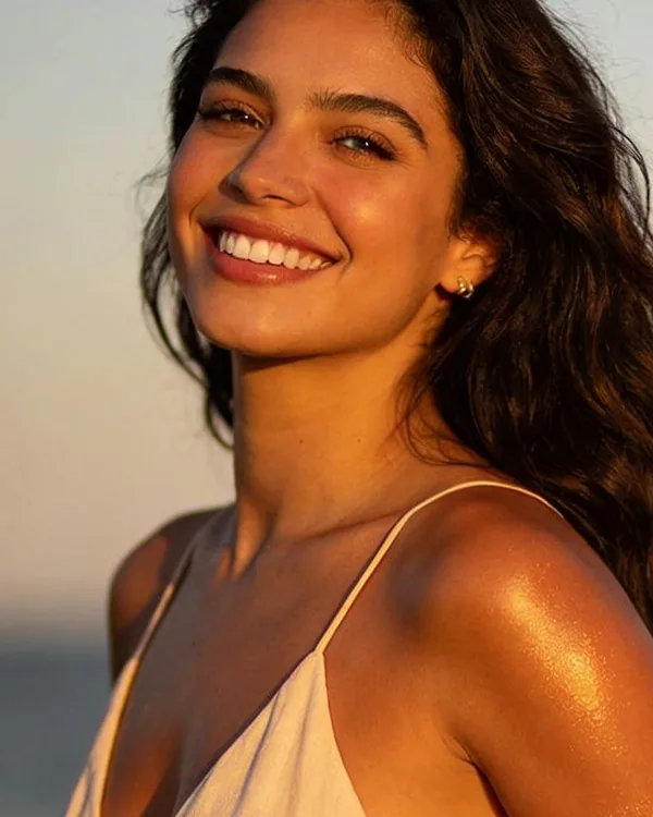 Mujer con bronceado dorado en la playa al atardecer